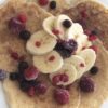 Zeigt die Protein Pancakes serviert mit Beeren und Bananae