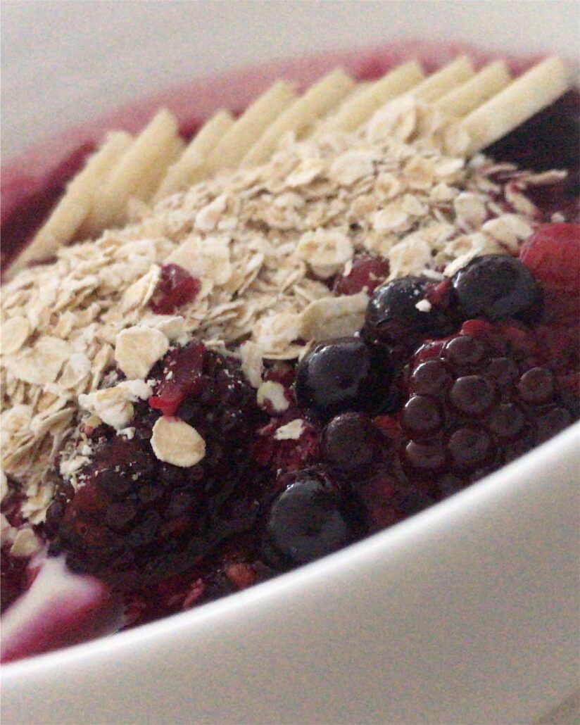 Zeigt das Porridge mit Beeren und Bananen